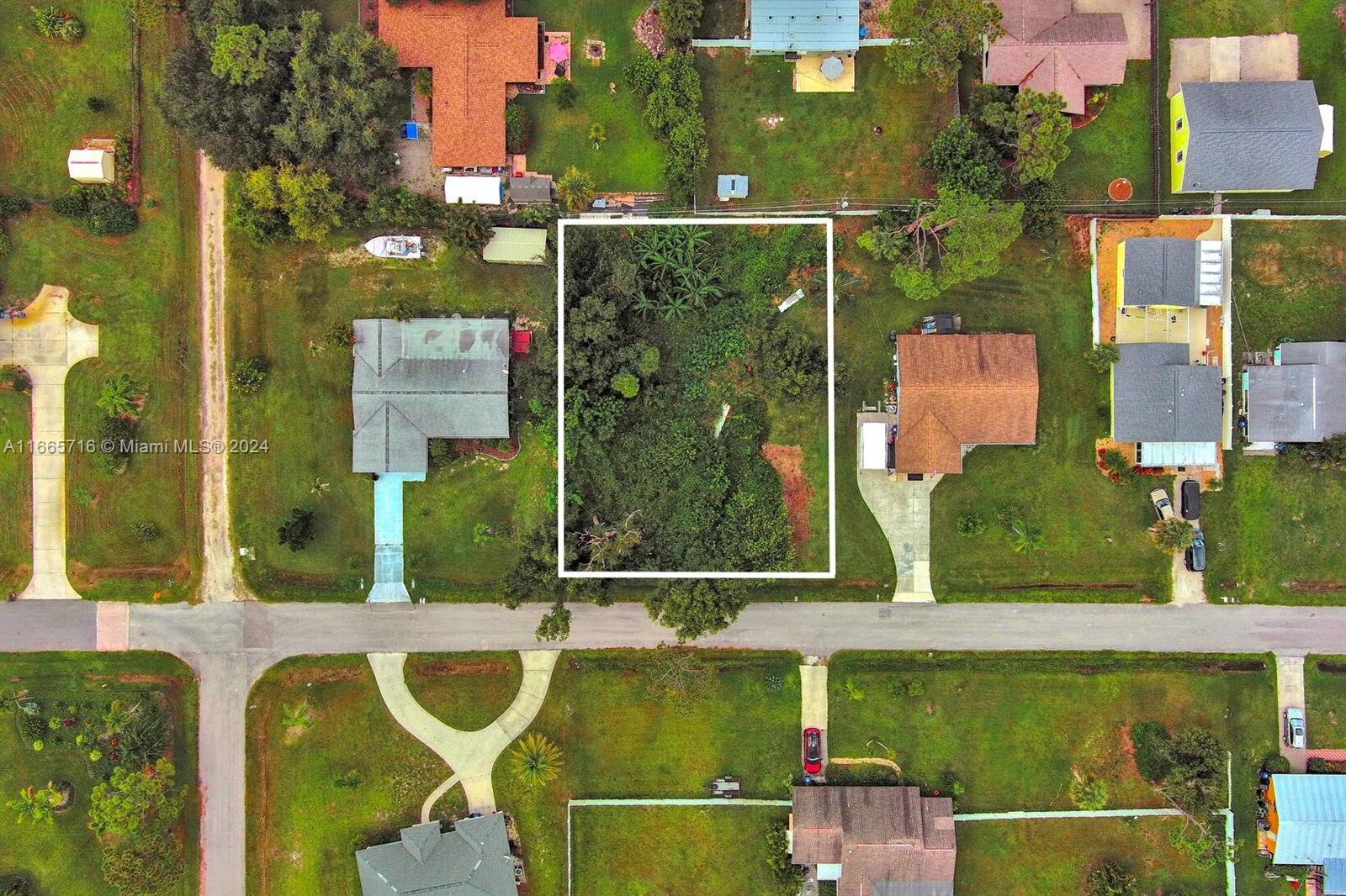An aerial view shows a vacant, tree-covered lot outlined in white between two residential houses — 1 Gillespie St, Englewood FL 34223, ENGLEWOOD, FL