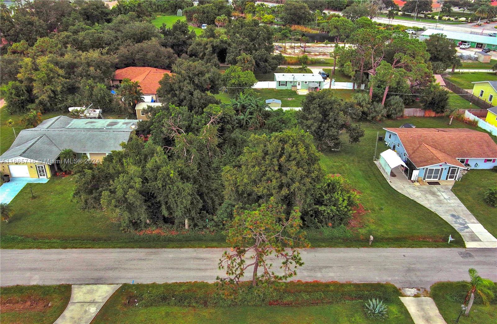 An aerial view shows a residential street with two houses separated by a wooded lot — 1 Gillespie St, Englewood FL 34223, ENGLEWOOD, FL