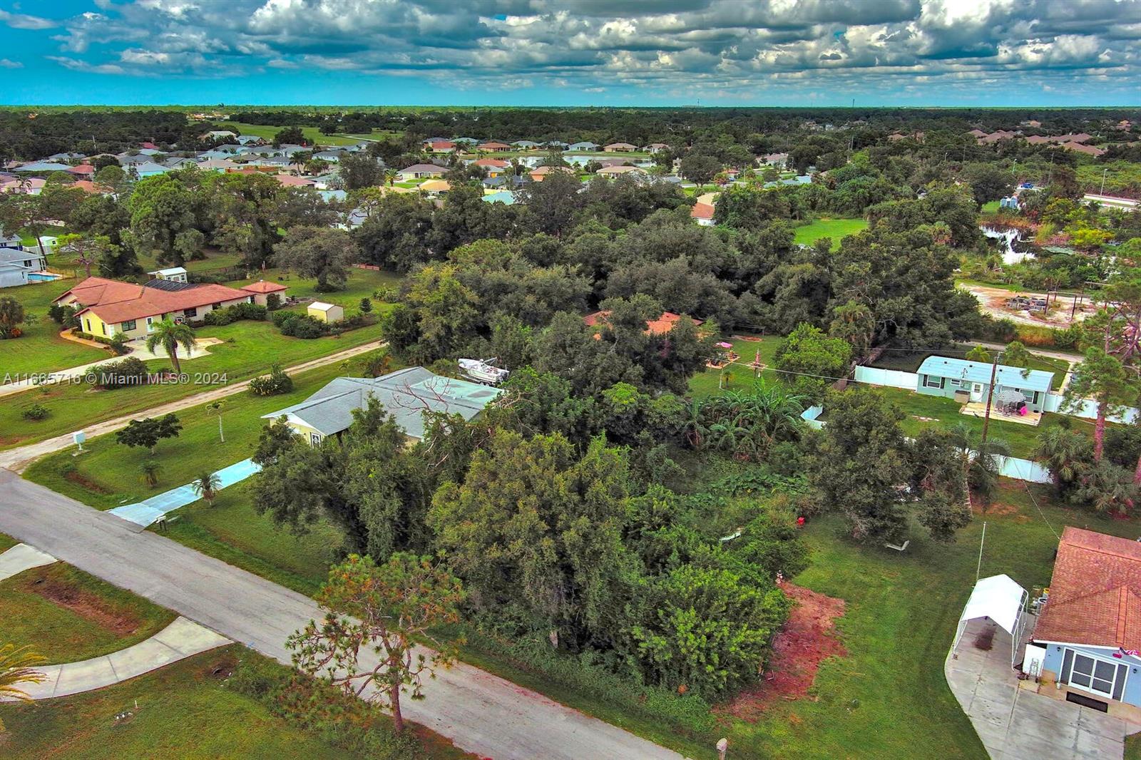 An aerial view shows a residential neighborhood with houses, dense trees, and a paved road — 1 Gillespie St, Englewood FL 34223, ENGLEWOOD, FL