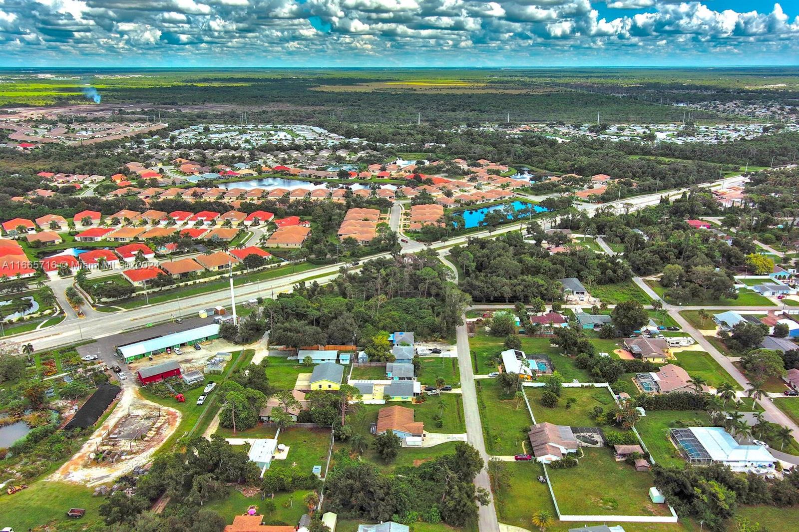 An aerial view shows a suburban neighborhood with houses, green lawns, and a nearby road — 1 Gillespie St, Englewood FL 34223, ENGLEWOOD, FL