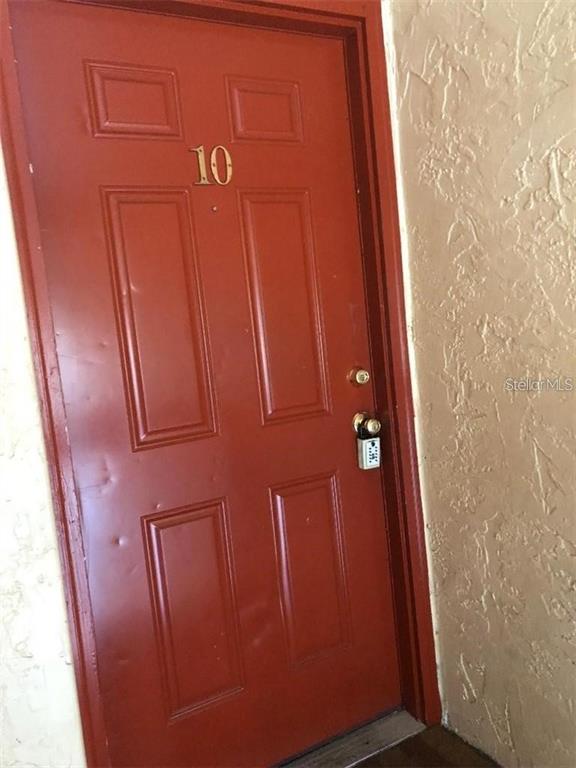 A red door marked with the number 10 features a mounted lockbox — 4213 S SEMORAN BOULEVARD UNIT 10, ORLANDO, FL