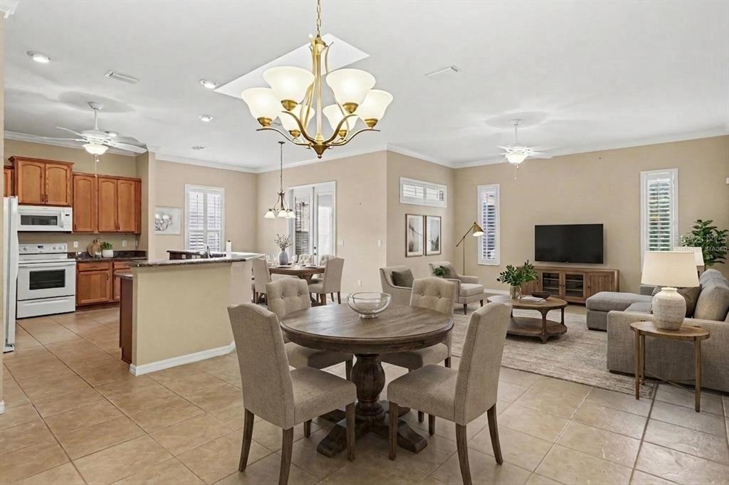An open-concept living and dining area features a kitchen with wood cabinets and tile floors — 10888 SE 170TH LANE ROAD, SUMMERFIELD, FL