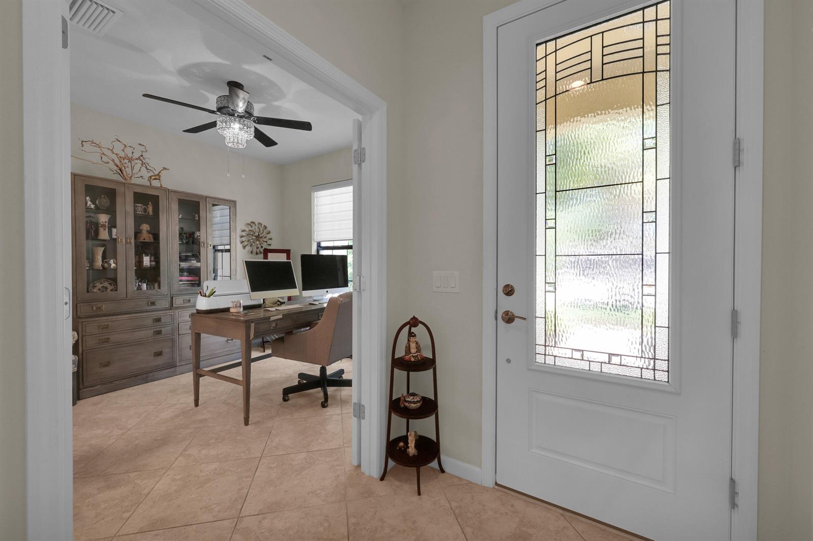 A home office with a desk and hutch is visible through a doorway near an entryway — 5040 Pendelton Square, Vero Beach FL 32967, VERO BEACH, FL