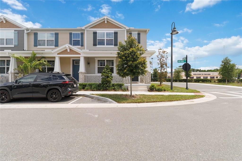A two-story townhouse with a black SUV parked in front and a street sign nearby — 1326 TARFLOWER DRIVE, WINTER SPRINGS, FL