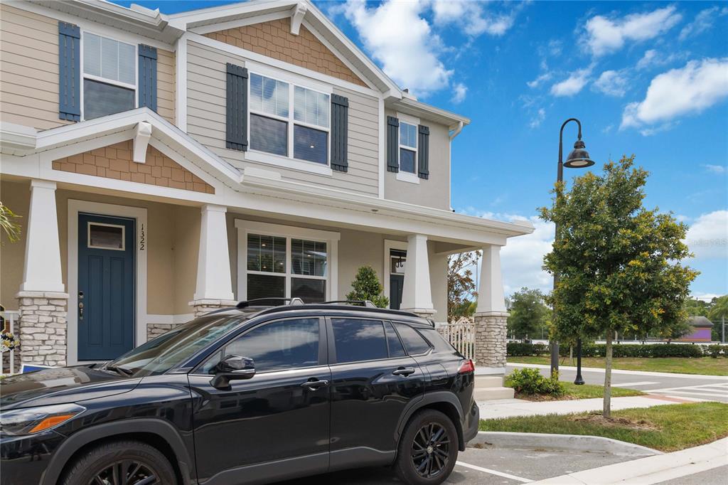 A black SUV is parked in front of a two-story townhouse with a covered porch — 1326 TARFLOWER DRIVE, WINTER SPRINGS, FL