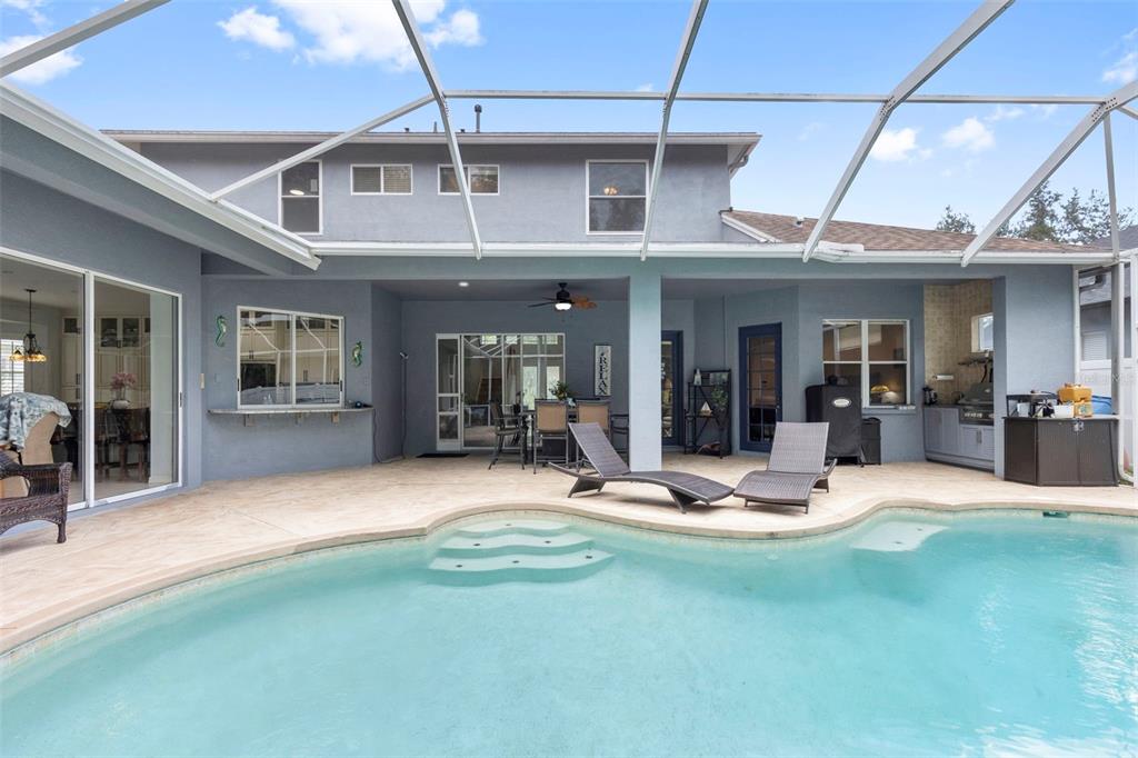A backyard swimming pool with a screened-in patio and outdoor kitchen area — 8380 GOLDEN PRAIRIE DRIVE, TAMPA, FL
