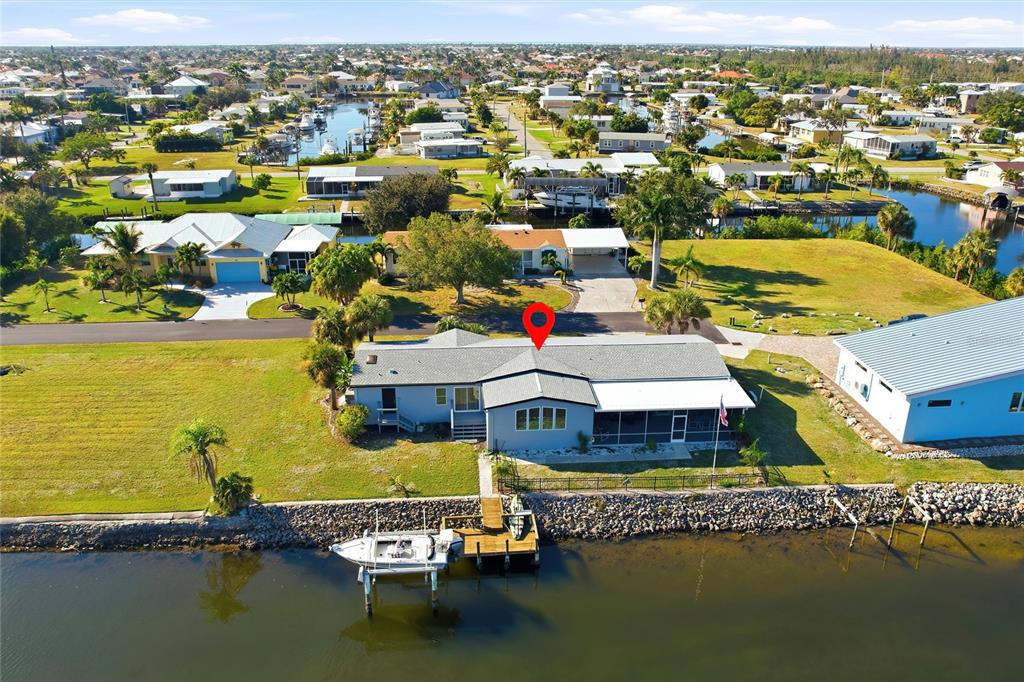 An aerial view of a waterfront house with a private dock and boat — 4190 PELICAN POINTE DRIVE, PUNTA GORDA, FL