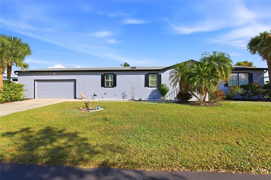 A single-story house with a gray exterior, a two-car garage, and palm trees — 4190 PELICAN POINTE DRIVE, PUNTA GORDA, FL