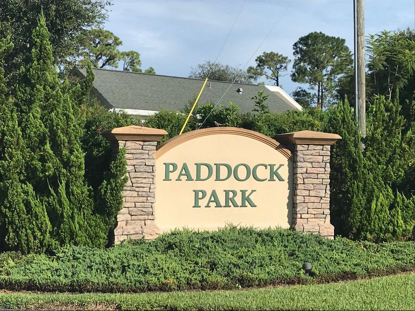 A stone-accented monument sign for Paddock Park stands surrounded by green landscaping and trees — 14779 Paddock Drive, Wellington FL 33414, WELLINGTON, FL