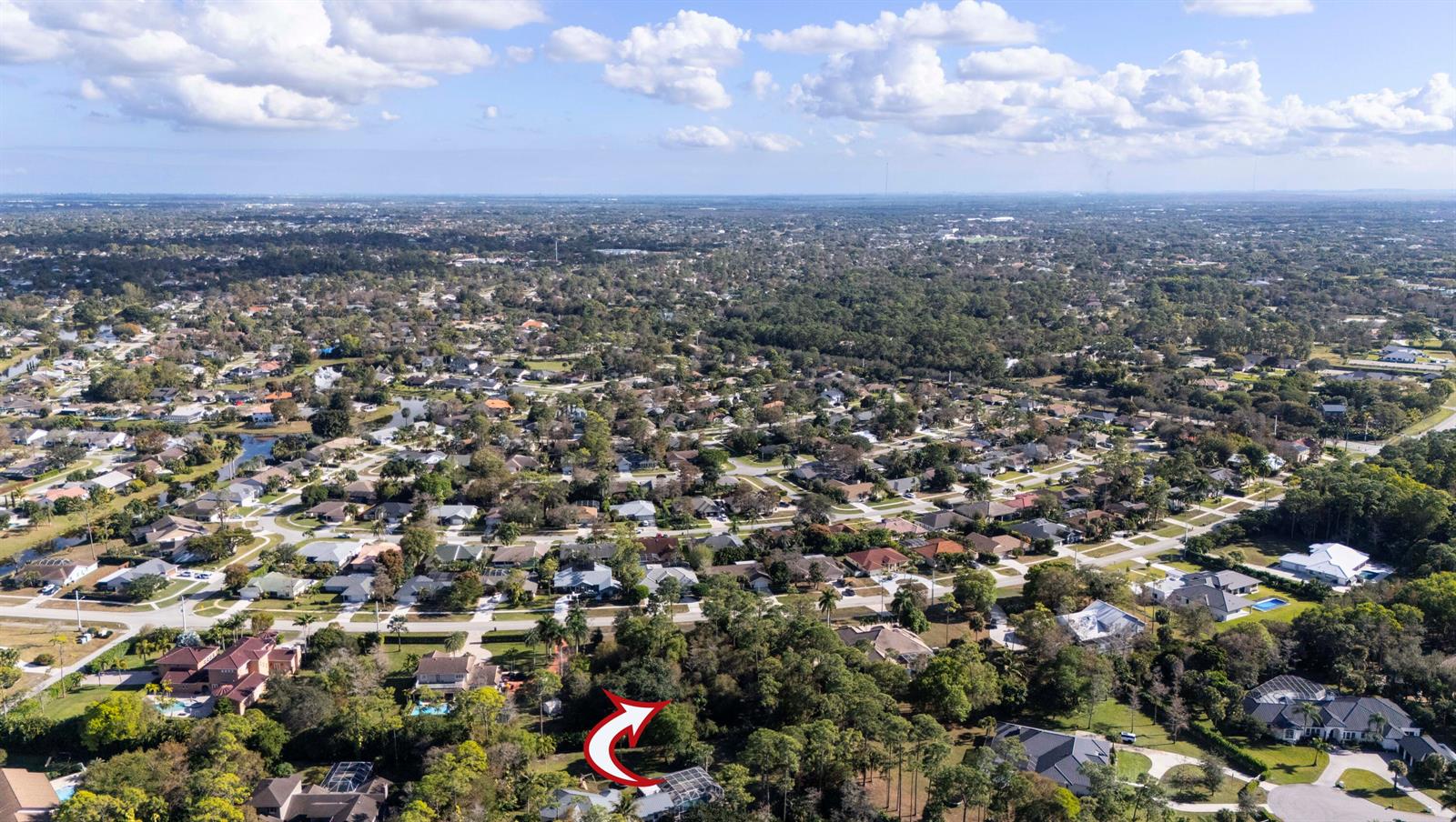 An aerial view shows a residential neighborhood with a red arrow pointing toward a house — 14779 Paddock Drive, Wellington FL 33414, WELLINGTON, FL