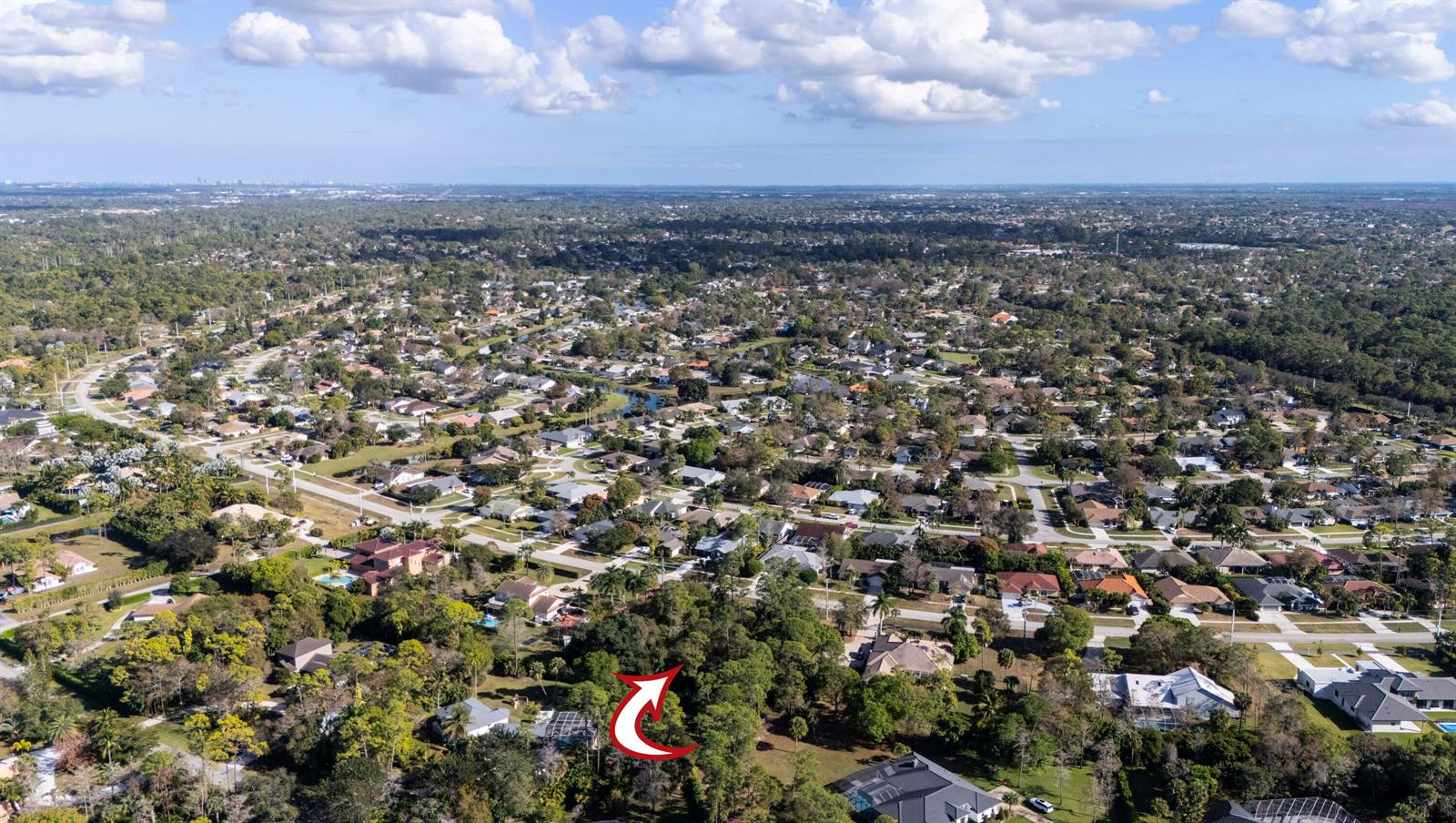 An aerial view shows a residential neighborhood with a red arrow pointing toward a wooded lot — 14779 Paddock Drive, Wellington FL 33414, WELLINGTON, FL