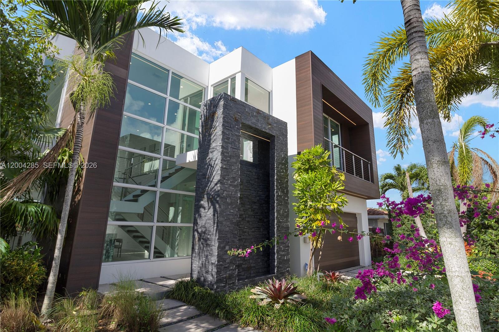 A modern two-story home features a stone facade, large glass windows, and a balcony — 2217 NE 17th Ter, Wilton Manors FL 33305, WILTON MANORS, FL