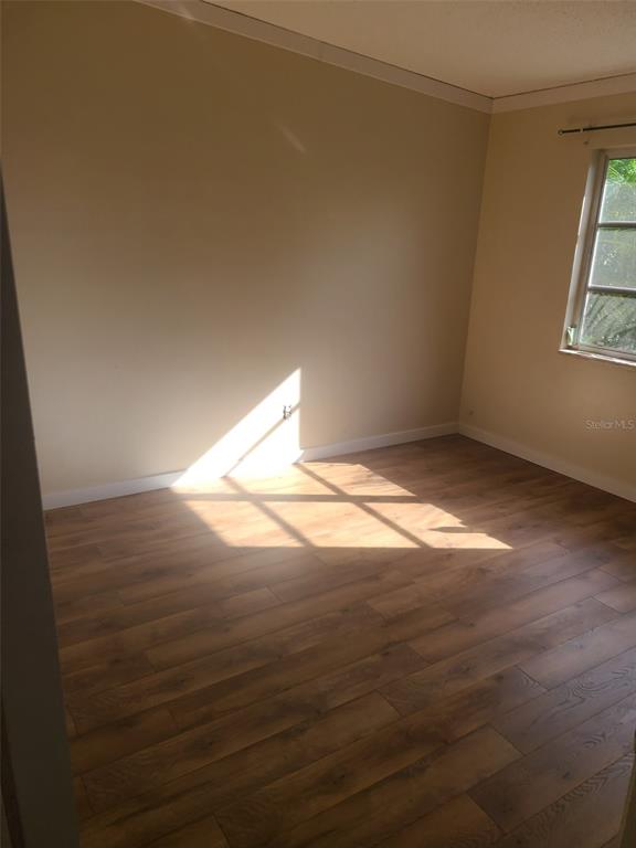 An empty bedroom features light-colored walls, a single window, and wood-look flooring — 6260 LANDOVER TERRACE, NORTH PORT, FL