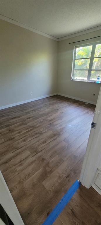 An empty bedroom features light-colored walls, a window, and wood-look laminate flooring — 6260 LANDOVER TERRACE, NORTH PORT, FL