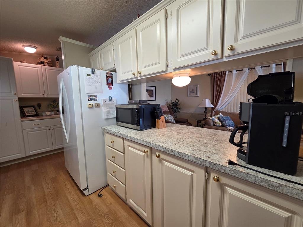 A kitchen features white cabinets, laminate countertops, and a white refrigerator — 4157 71ST LANE N UNIT 14, ST PETERSBURG, FL