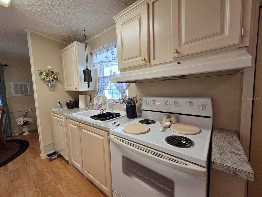 A kitchen features white cabinets, a white electric stove, and a laminate countertop — 4157 71ST LANE N UNIT 14, ST PETERSBURG, FL