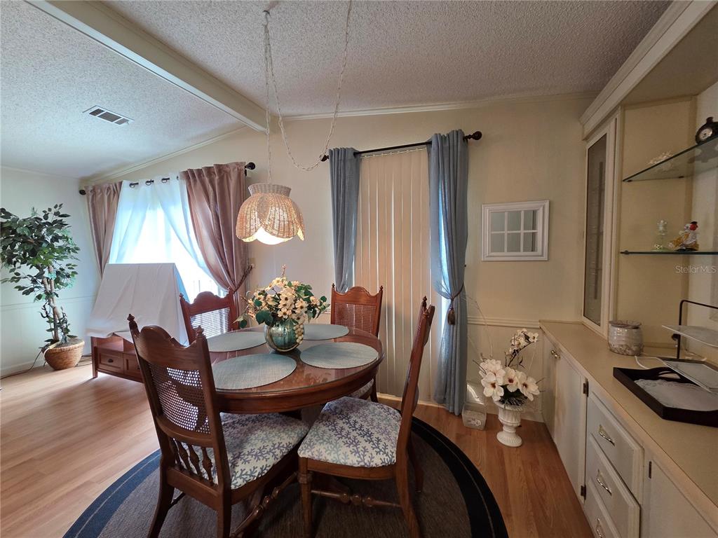 A dining room features a round wooden table, four chairs, and a built-in cabinet — 4157 71ST LANE N UNIT 14, ST PETERSBURG, FL