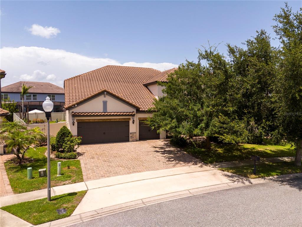 A two-story house with a tile roof, a brick driveway, and a three-car garage — 8457 MOREHOUSE DRIVE, ORLANDO, FL