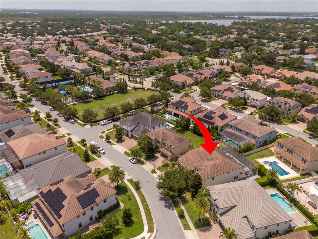 An aerial view shows a suburban neighborhood with houses featuring swimming pools and solar panels — 8457 MOREHOUSE DRIVE, ORLANDO, FL