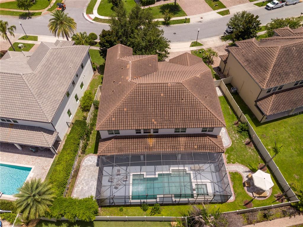 An aerial view shows a two-story house with a tiled roof and a screened-in pool — 8457 MOREHOUSE DRIVE, ORLANDO, FL