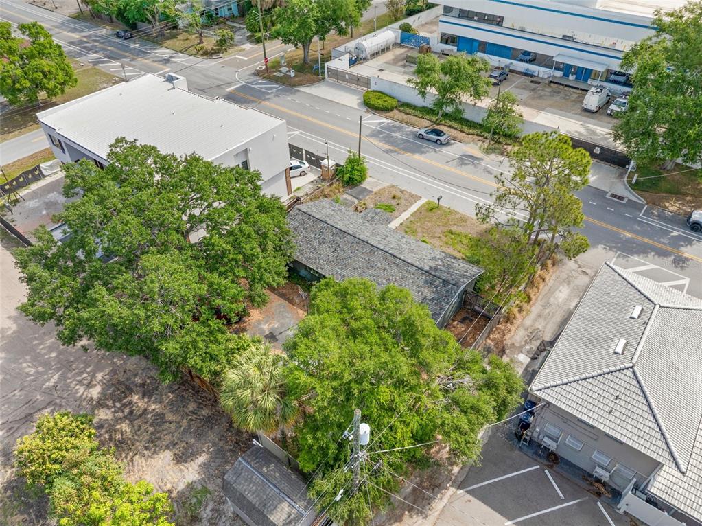 An aerial view shows a small house with a gray roof surrounded by mature trees — 110 N LINCOLN AVENUE, TAMPA, FL