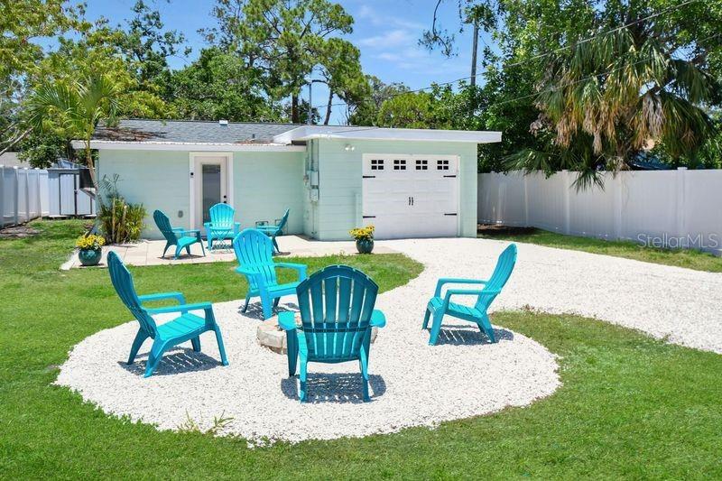A light green house features a yellow front door, a paved patio, and white fencing — 418 40TH AVENUE S, ST PETERSBURG, FL