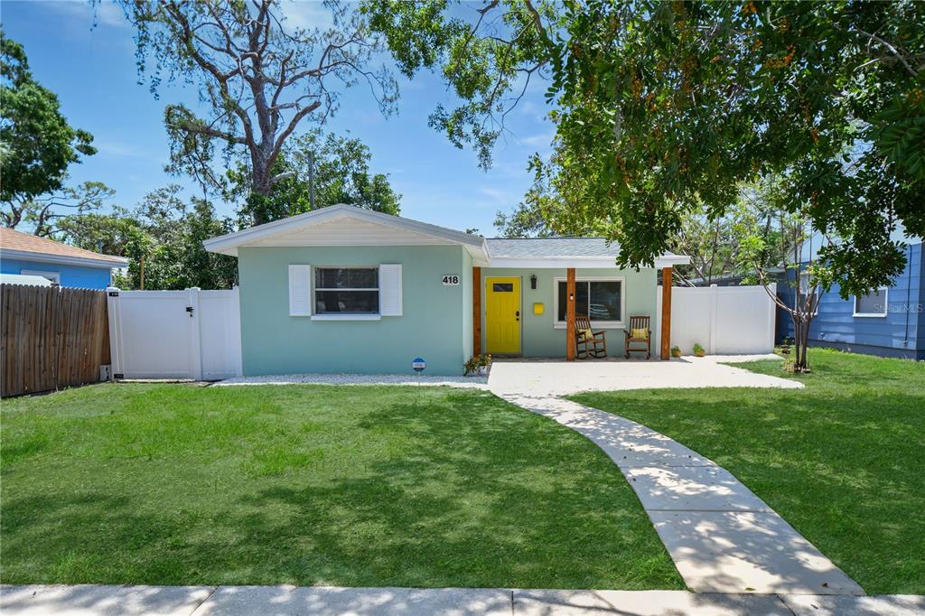A light green detached garage features a gravel patio area with several bright blue chairs — 418 40TH AVENUE S, ST PETERSBURG, FL