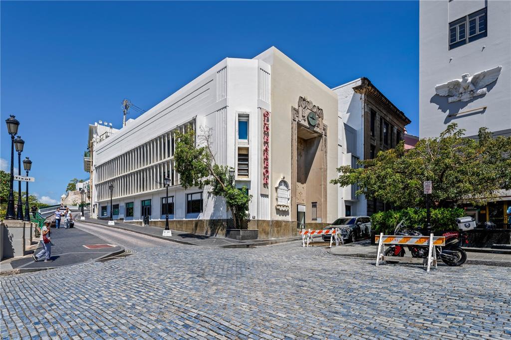 A white Art Deco building stands on a cobblestone street in a historic city — 201-202 TIZOL STREET, SAN JUAN, PR