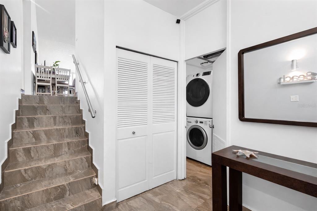 A staircase with stone tiles leads to a dining area next to a laundry closet — . BEACH VILLAGE UNIT 128, HUMACAO, PR