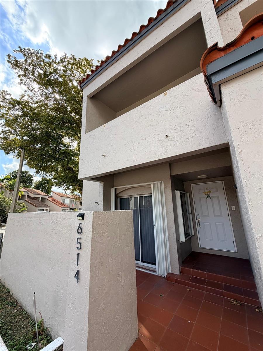 A two-story stucco townhouse exterior features a tiled entryway, a balcony, and a house number — 6514 SW 128th Pl # 6514, Miami FL 33183, MIAMI, FL