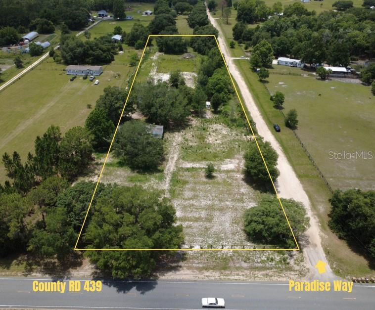 An aerial view shows a rectangular plot of land bordered by a road and trees — 38045 COUNTY ROAD 439, EUSTIS, FL