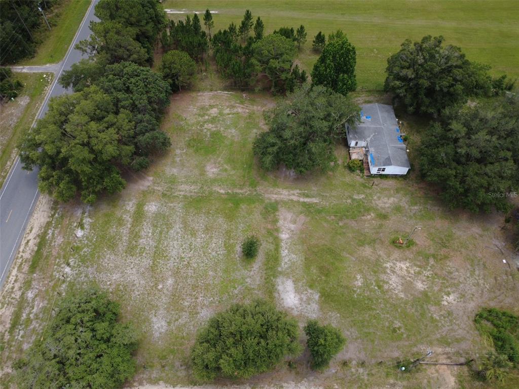 An aerial view shows a house situated on a large, partially wooded grassy lot — 38045 COUNTY ROAD 439, EUSTIS, FL