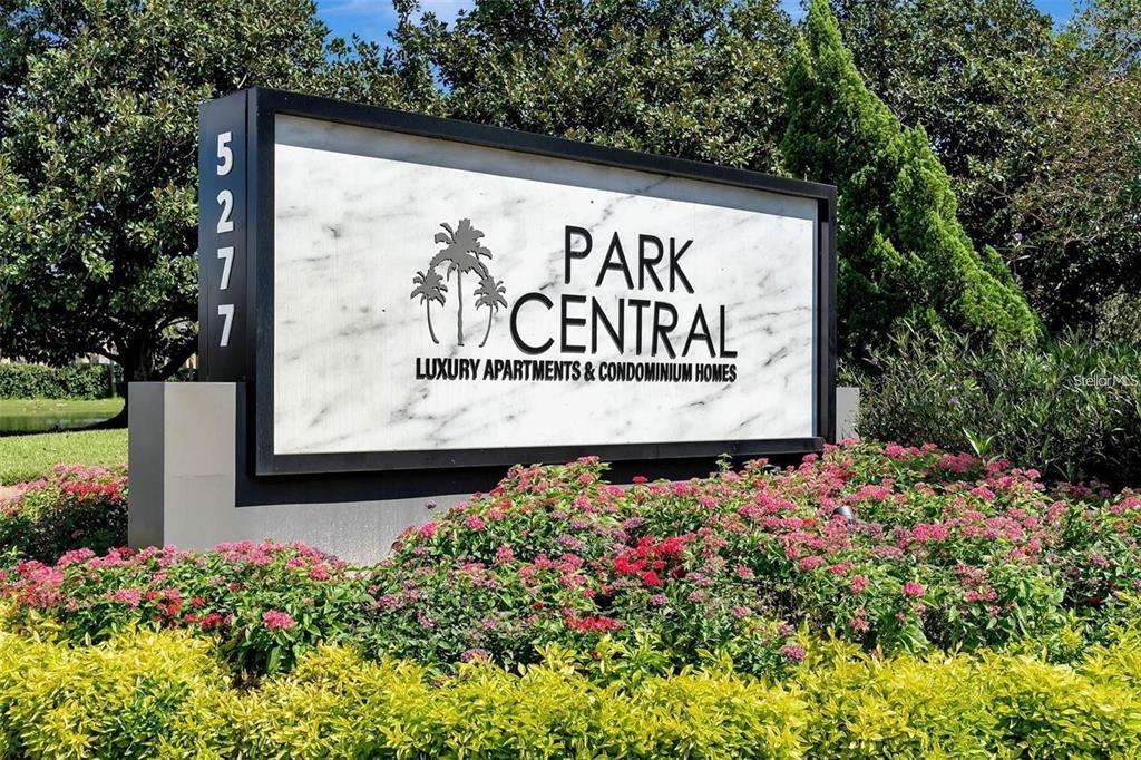 A sign for Park Central luxury apartments and condominium homes stands amidst landscaped garden beds — 5005 CITY STREET UNIT 1317, ORLANDO, FL