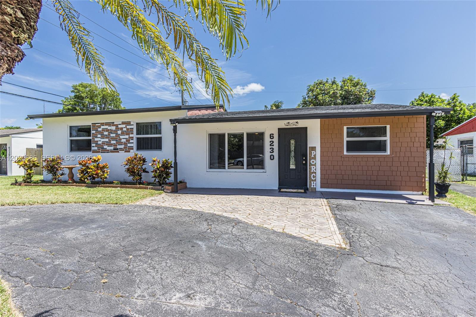 A single-story house features a white facade, brown shingle siding, and a paved driveway — 6230 SW 16th Ct, North Lauderdale FL 33068, NORTH LAUDERDALE, FL