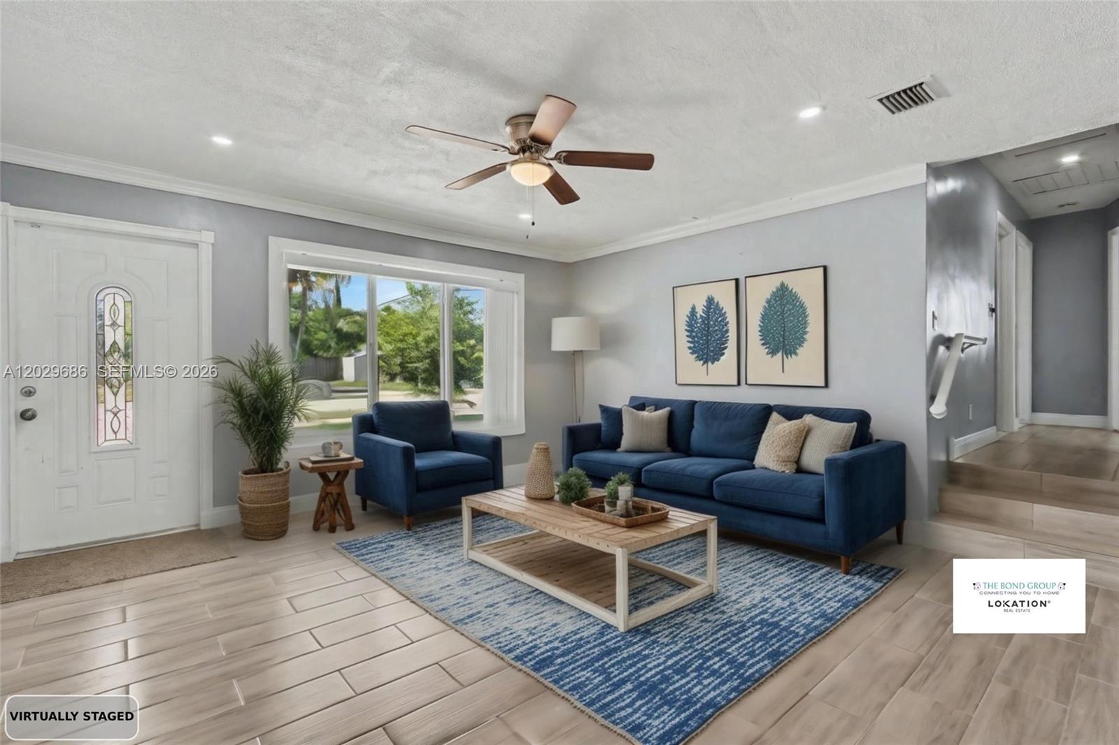 A living room features a blue sofa, matching armchair, wood coffee table, and light tile flooring — 6230 SW 16th Ct, North Lauderdale FL 33068, NORTH LAUDERDALE, FL