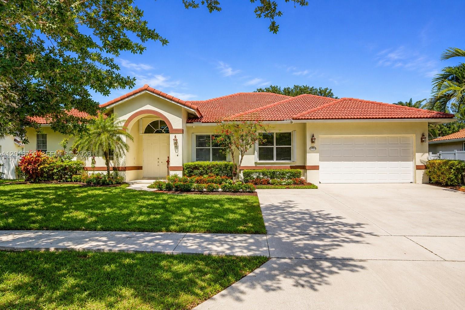 A single-story house with a red tile roof, white garage door, and landscaped front yard — 4401 SW 74th Ter, Davie FL 33314, DAVIE, FL