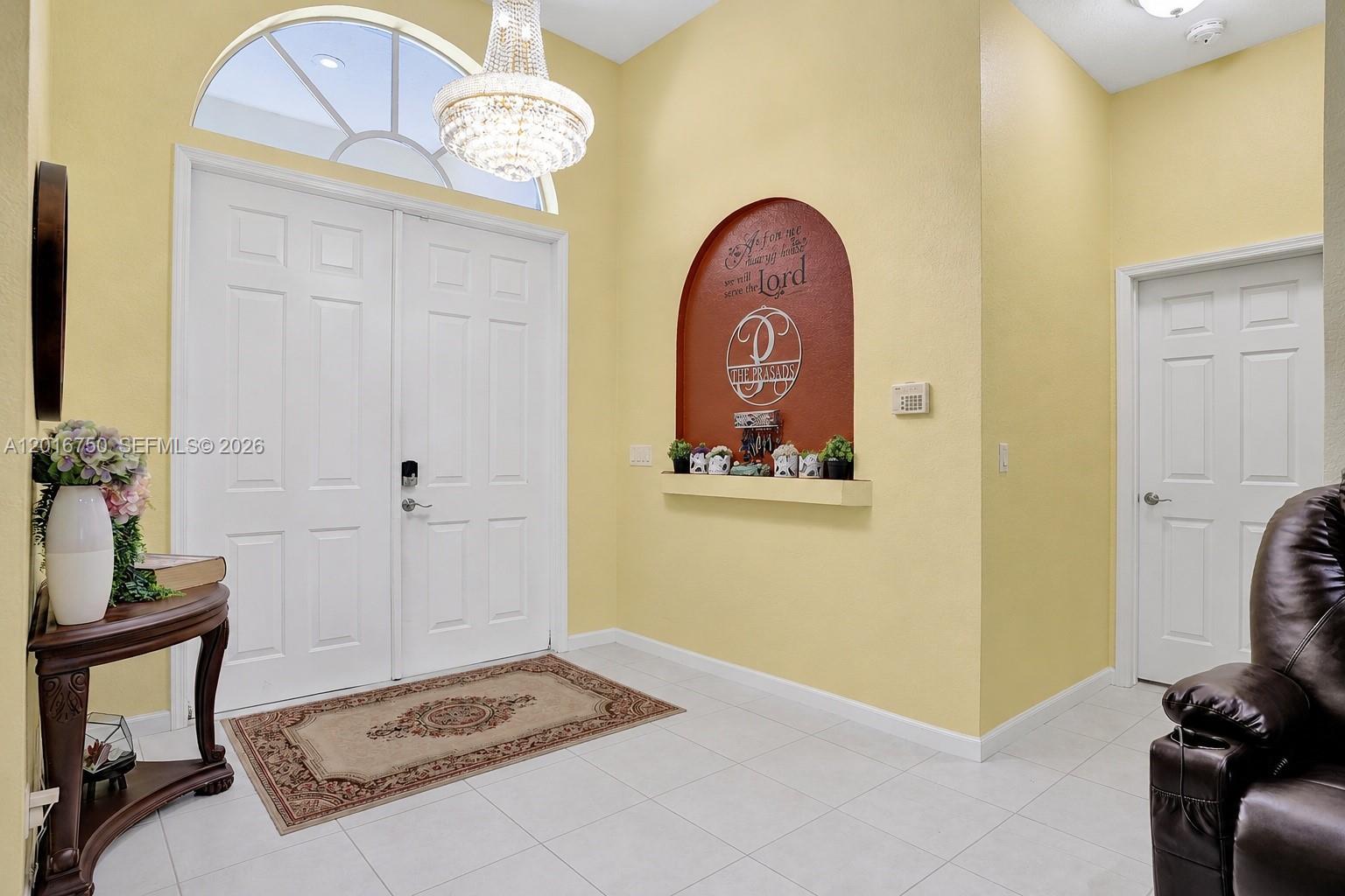 A bright entryway features a double door, a chandelier, and a decorative arched wall niche — 4401 SW 74th Ter, Davie FL 33314, DAVIE, FL