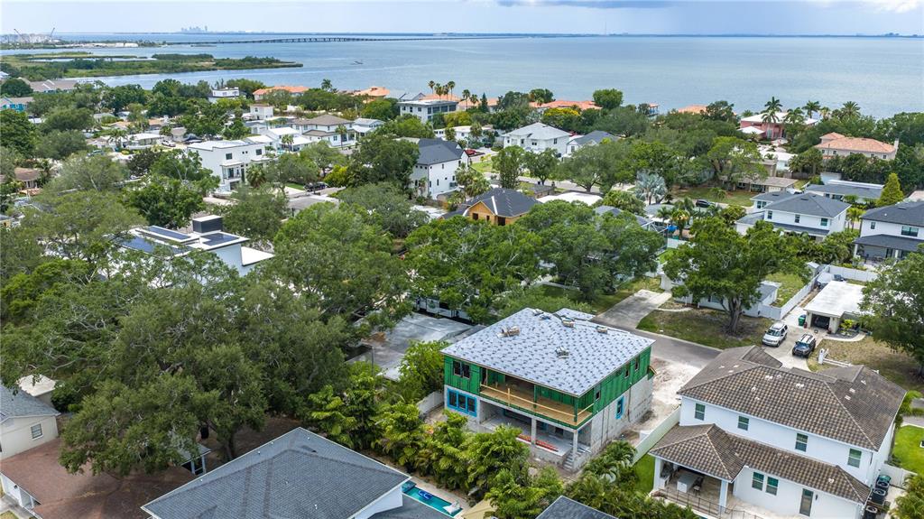 An aerial view shows a residential neighborhood with a house under construction near water — 3618 S GARDENIA AVENUE, TAMPA, FL