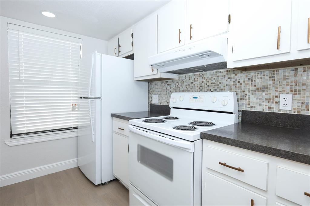 A kitchen features white cabinets, a white refrigerator, a white electric stove, and mosaic tile backsplash — 4029 HENLEY ROAD UNIT 1705, ORLANDO, FL