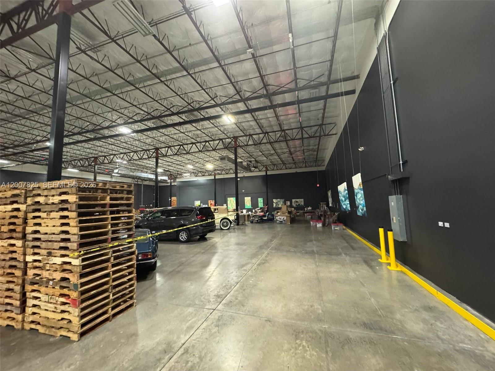 A large warehouse space features a concrete floor, high exposed ceilings, and black walls — 3450 NW 115th Ave, Doral FL 33178, DORAL, FL
