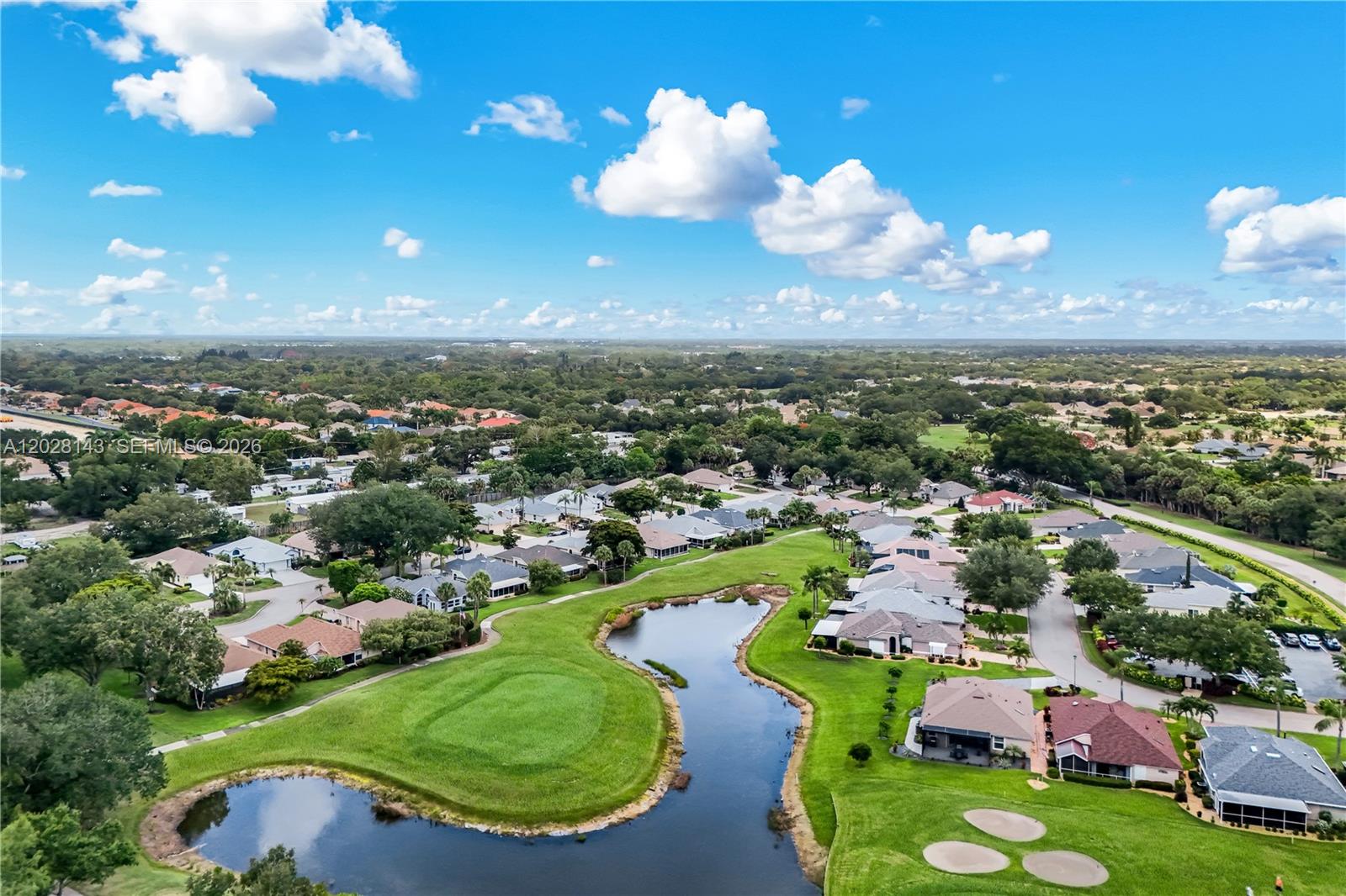 An aerial view shows a residential neighborhood surrounding a golf course pond and green — 21167 Butchers Holler, Estero FL 33928, ESTERO, FL