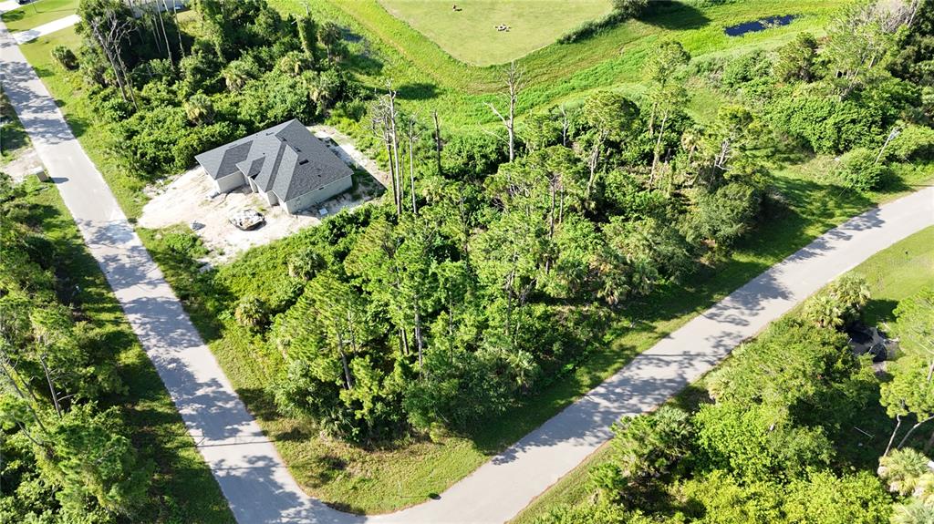 An aerial view shows a house under construction on a wooded lot between two roads — N SAN MATEO DRIVE, NORTH PORT, FL