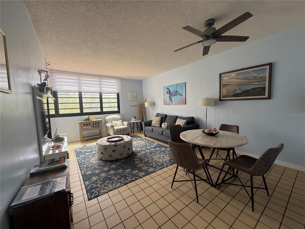 A living and dining area with tile floors, a ceiling fan, and a blue rug — DR BEACH VILLAGE UNIT 119, HUMACAO, PR