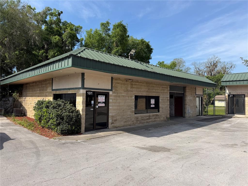 A single-story commercial building with a green metal roof and tan stone exterior walls — 1706 N MAGNOLIA AVENUE UNIT 101, OCALA, FL