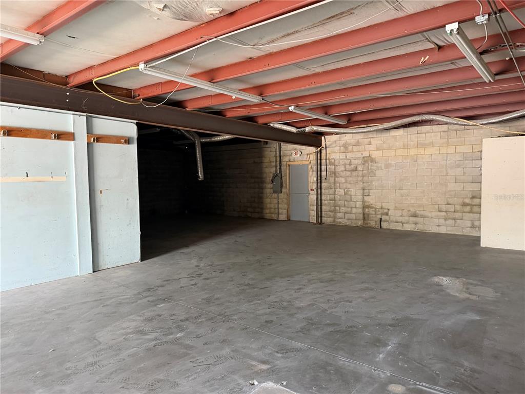 An empty industrial warehouse space features a concrete floor, exposed steel beams, and block walls — 1706 N MAGNOLIA AVENUE UNIT 101, OCALA, FL