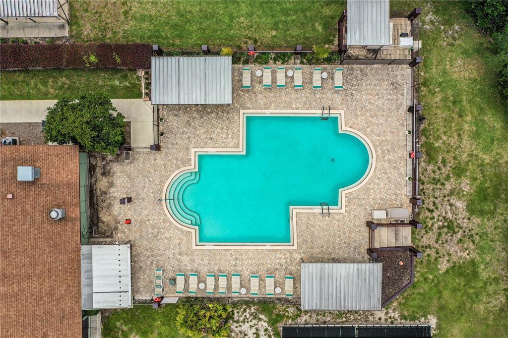 An aerial view shows a swimming pool with a paved deck, lounge chairs, and covered patios — 4235 CERIMEN STREET, LAKE WALES, FL