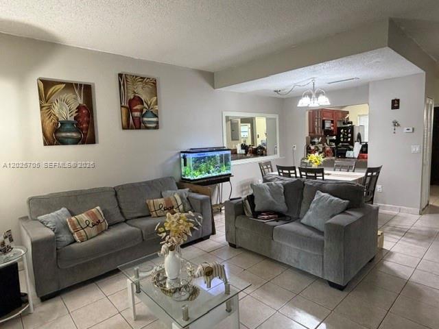 A living room features two gray sofas, a glass coffee table, and an aquarium — 4424 W 12th Ln # 7, Hialeah FL 33012, HIALEAH, FL