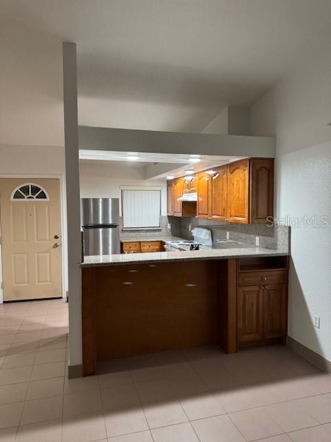 A kitchen features wood cabinets, a granite countertop, and stainless steel appliances — 25385 SANDHILL BOULEVARD UNIT D2, PUNTA GORDA, FL