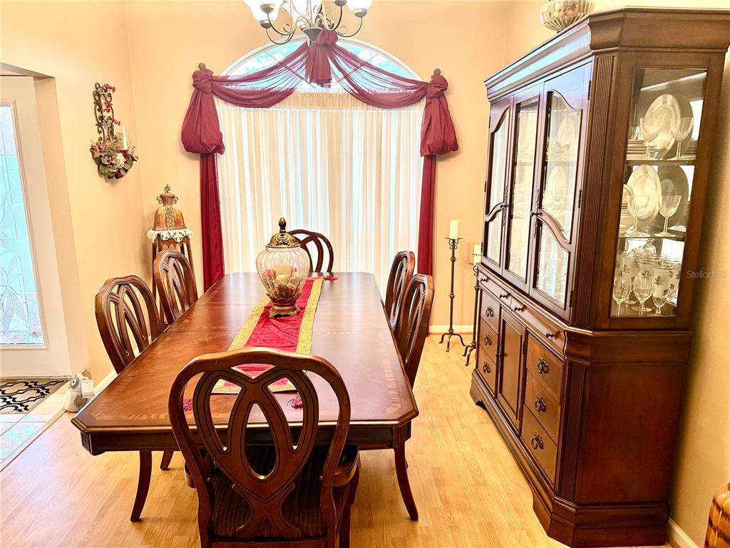 A dining room features a wooden table, chairs, a large hutch, and draped window curtains — 68 RIVERVIEW DRIVE, PALM COAST, FL