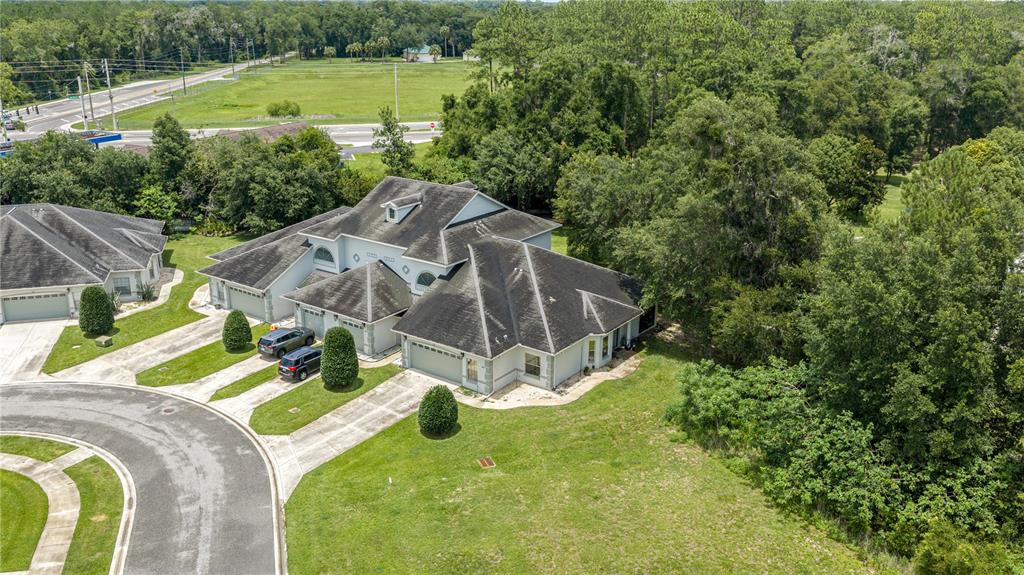 An aerial view shows a large suburban house with a multi-car garage and dark roof — 3415 W ANTHONY ROAD UNIT 404, OCALA, FL